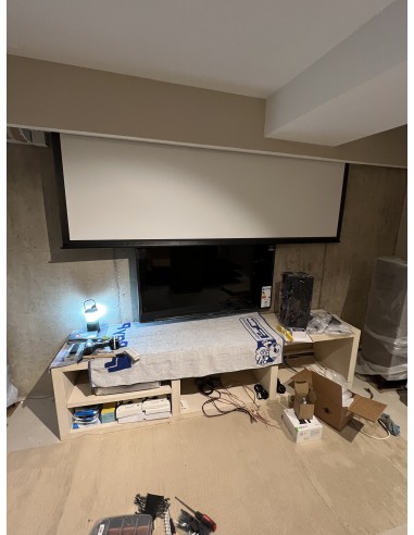 Sala de cine en casa con proyector y televisión