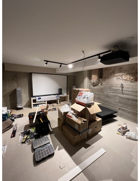 Sala de cine en casa con proyector y televisión