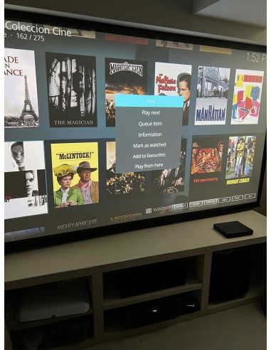 Sala de cine en casa con proyector y televisión