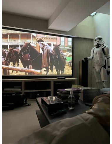 Sala de cine en casa con proyector y televisión