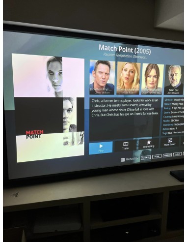 Sala de cine en casa con proyector y televisión